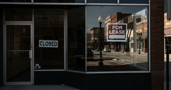 A vacant storefront displays a "For Lease" sign. A "Closed" sign hangs in the window.
