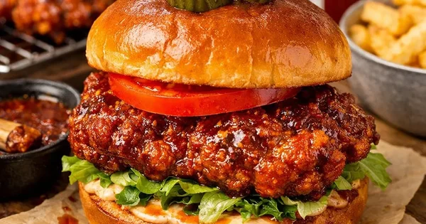 A spicy chicken sandwich is topped with pickles.