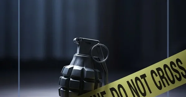 A grenade lies on the ground behind police line tape.