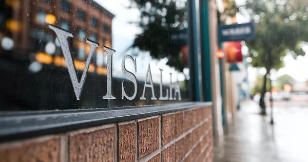 Raindrops cover a storefront window in downtown Visalia.