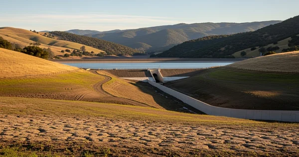 Low water levels and cracked earth are visible at a reservoir as drought conditions persist in the region.