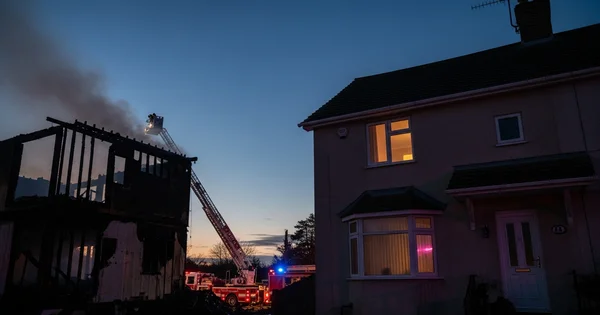 Firefighters work to extinguish a house fire.