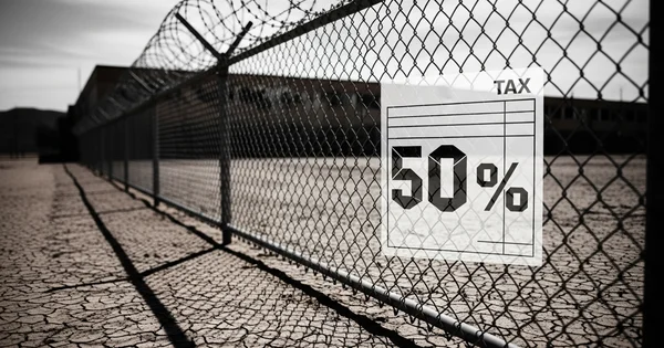 A graphic depicting a 50 percent tax rate hangs on a security fence topped with barbed wire.